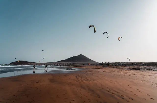 Kitesurfers op het strand van El Médano met Montaña Roja